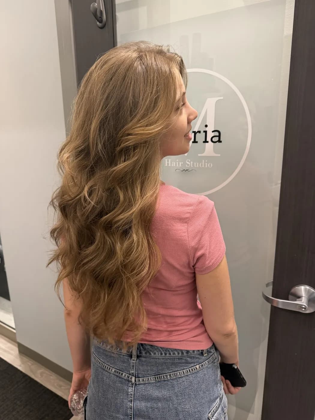 Long honey-blonde waves after a sewn-in weft extension install