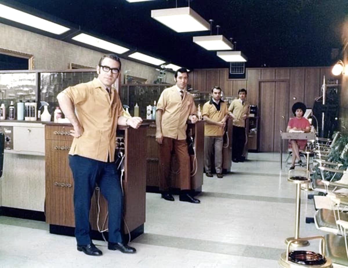Five barbers in matching shirts lined up inside Madison Men's Barbershop